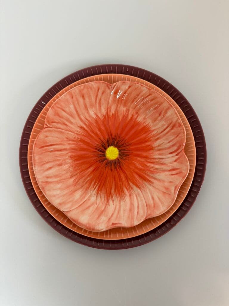 Dekorative tallerkener med blomstermotiv i røde nuancer