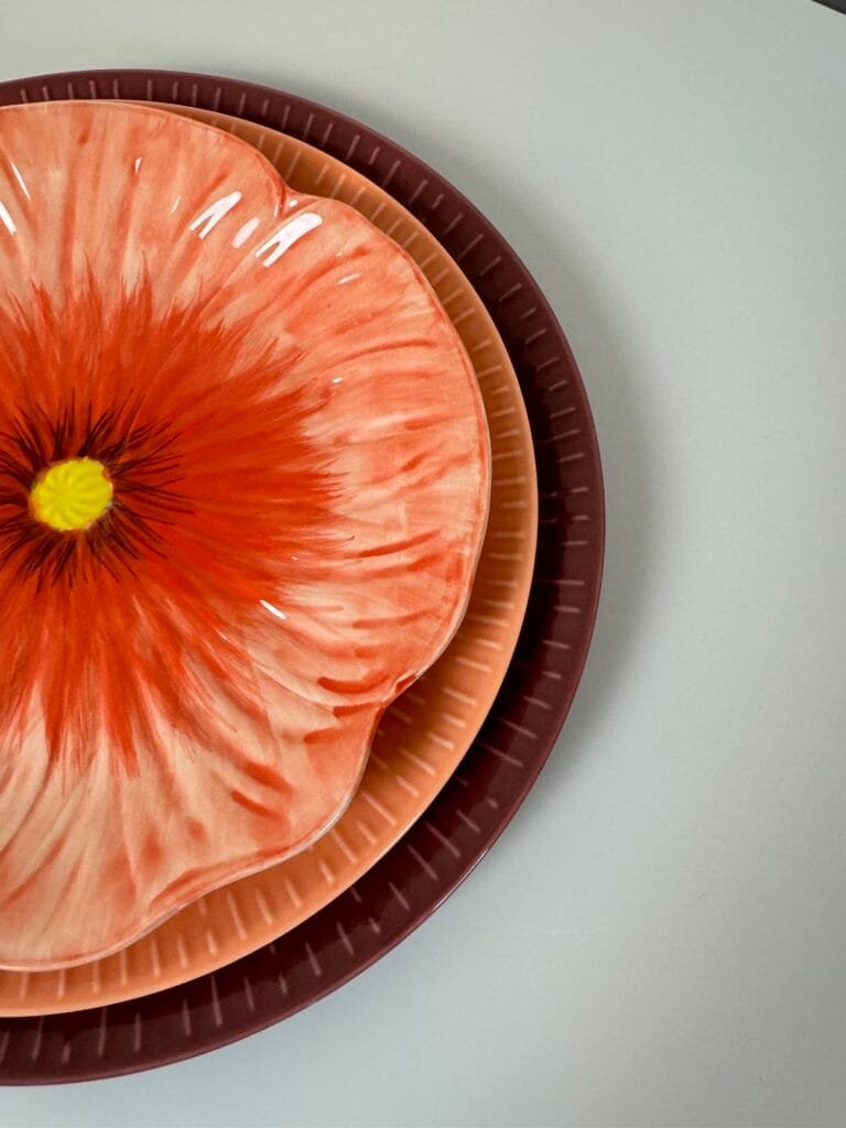 Farverige tallerkener stablet på hvidt bord