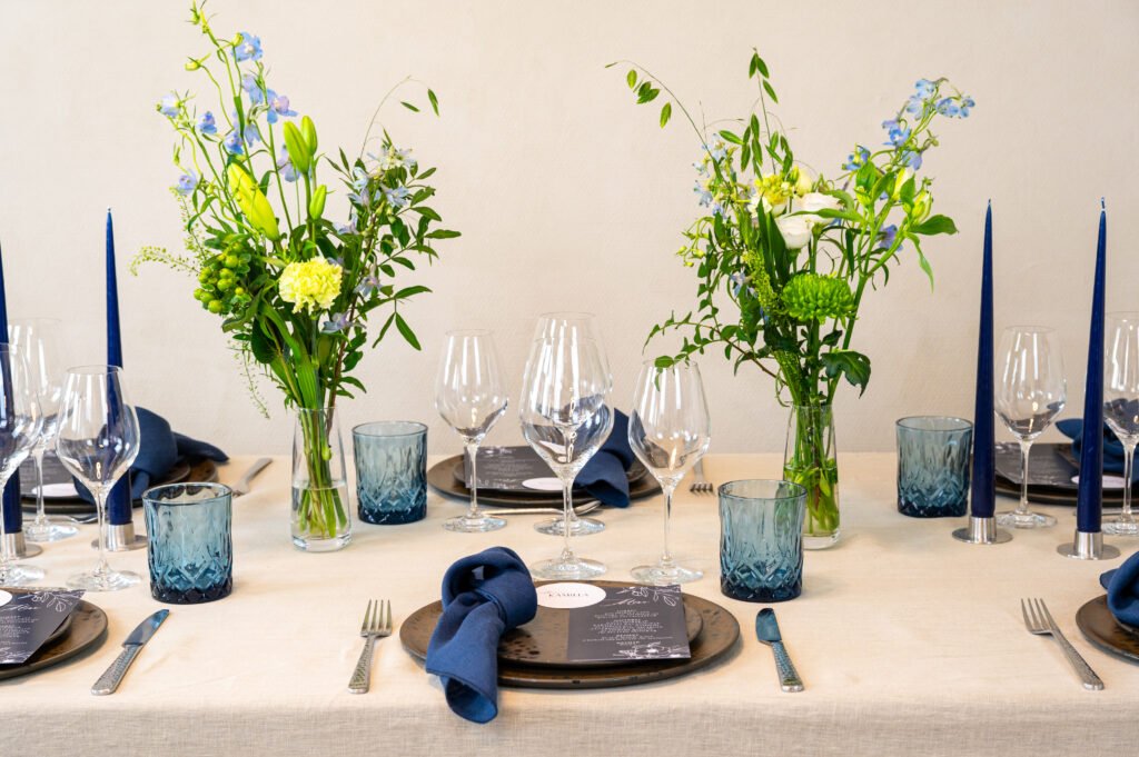 Elegant opdækket bord med blomster og blå detaljer