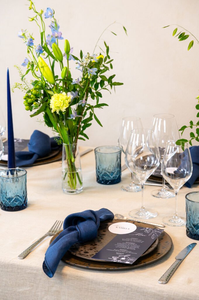 Elegant borddækning med blomster og blå detaljer