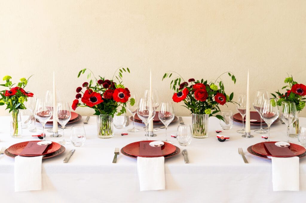 Elegant middagsselskab med røde blomster og stearinlys
