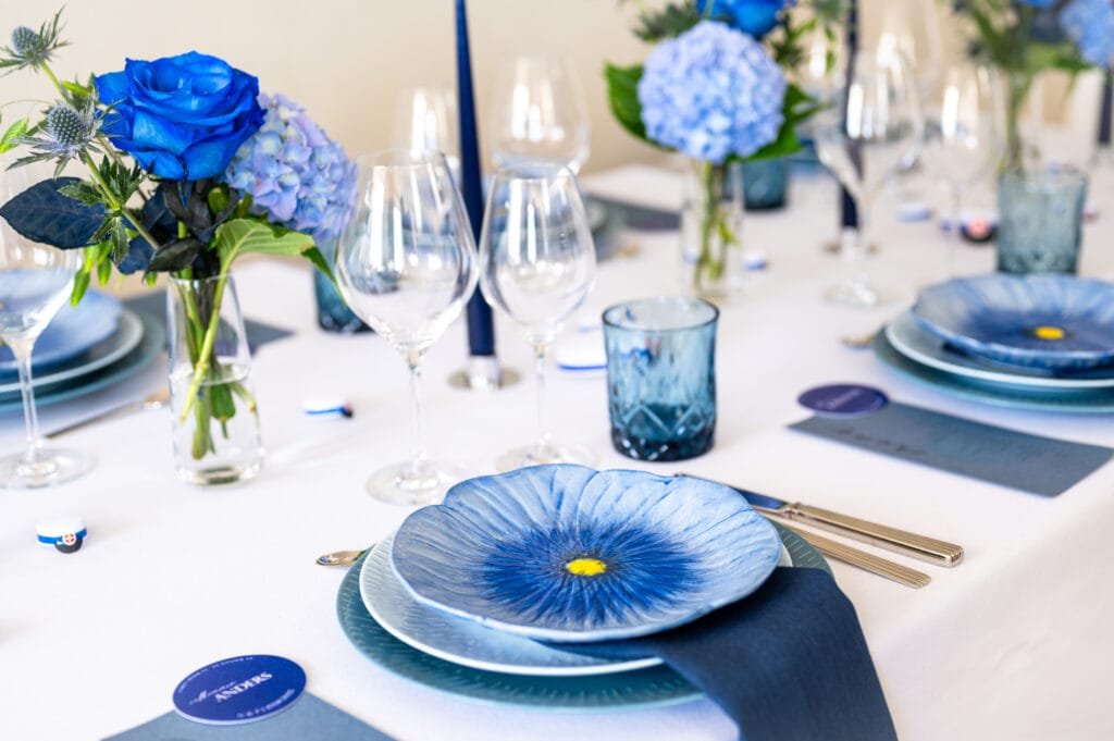 Elegant borddækning med blå blomster og service