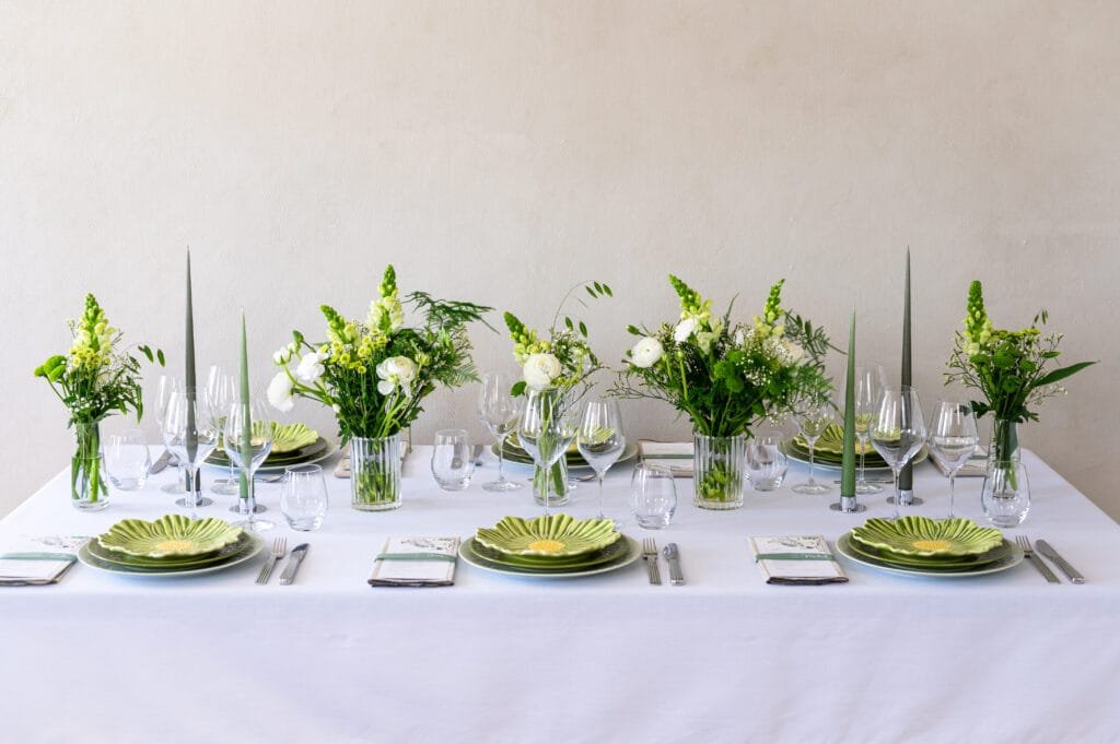 Elegant borddækning med blomster og grønne tallerkener