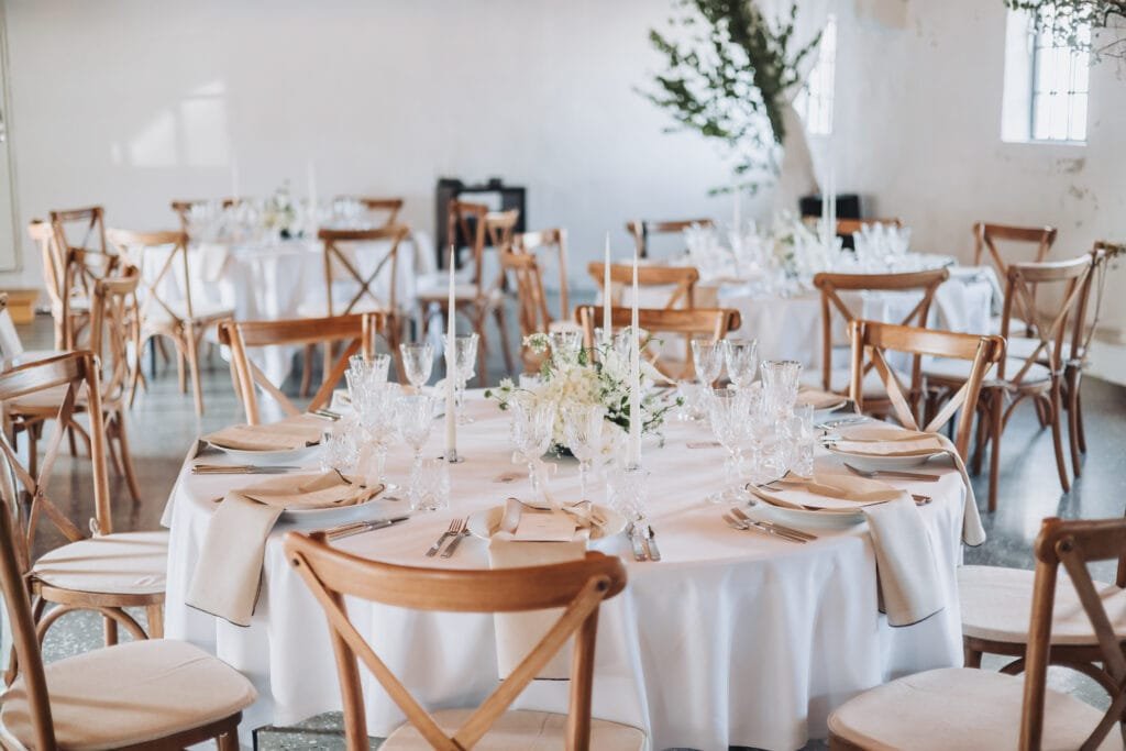 Elegant bryllupsbord dækket med blomster og stearinlys