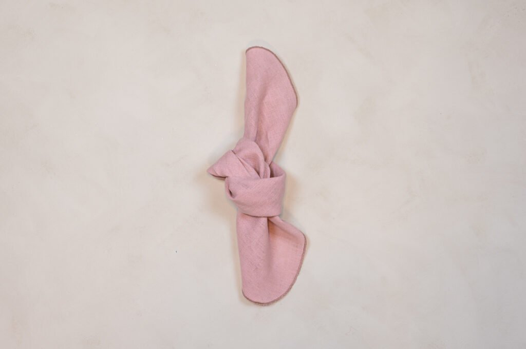 Lyserød stofserviet bundet i knude