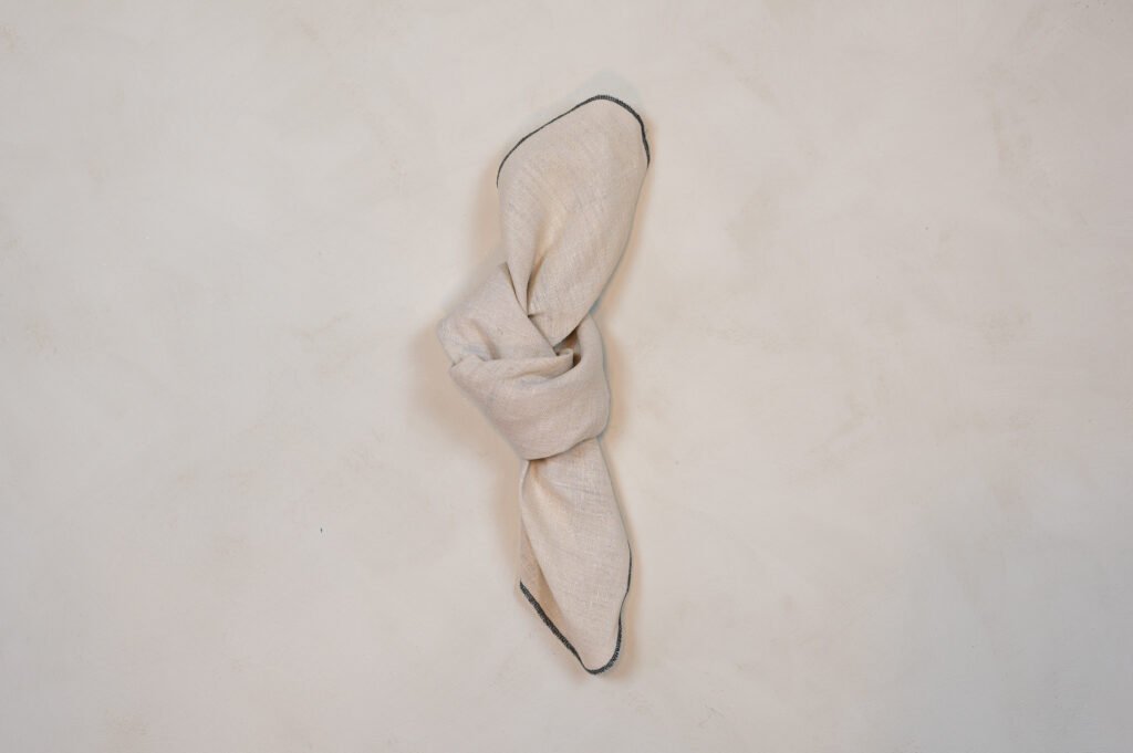Beige serviet foldet i knude