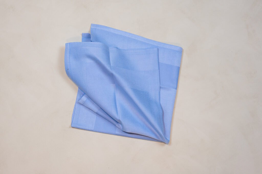 Sammenfoldet lyseblåt viskestykke på lys overflade