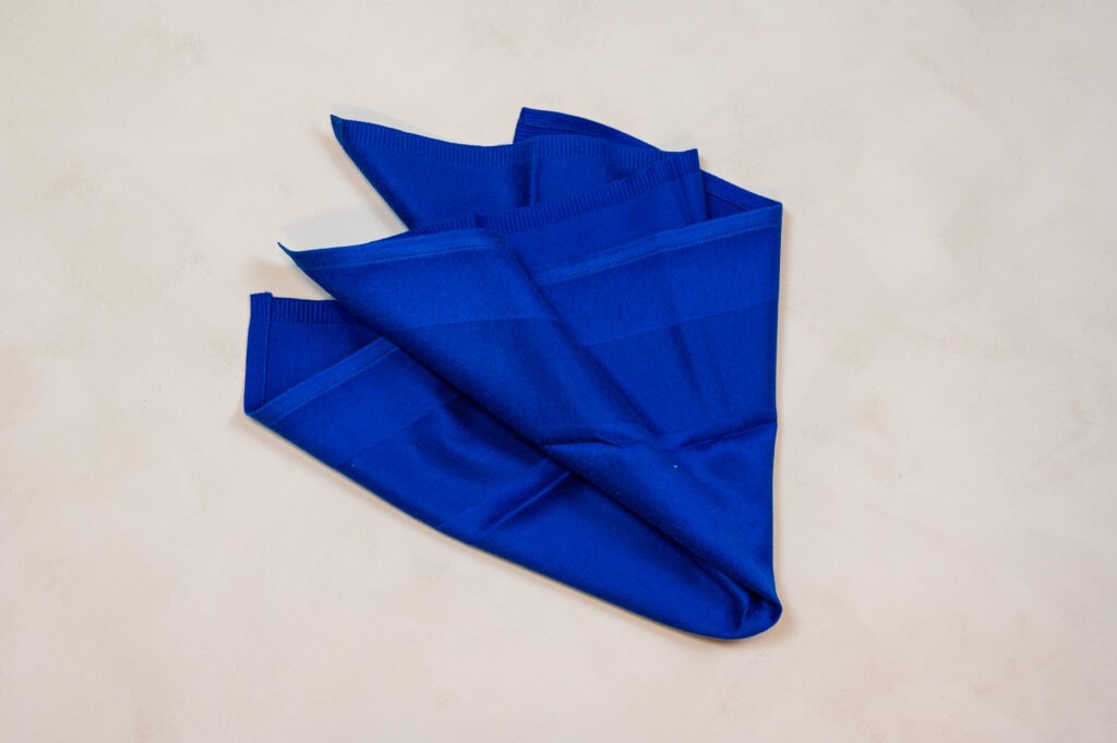 Sammenfoldet blåt stofserviet på bord