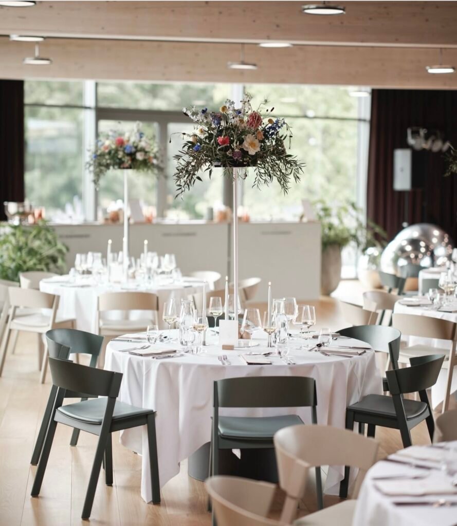 Elegant festlokale med runde borde og blomsterdekorationer