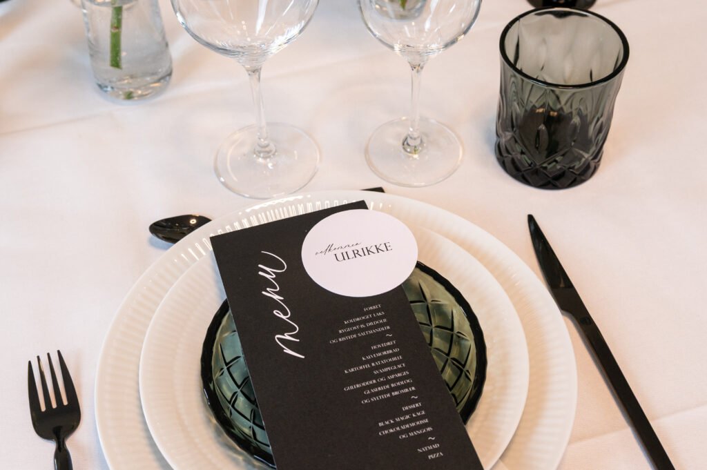 Elegant borddækning med menu og vinglas