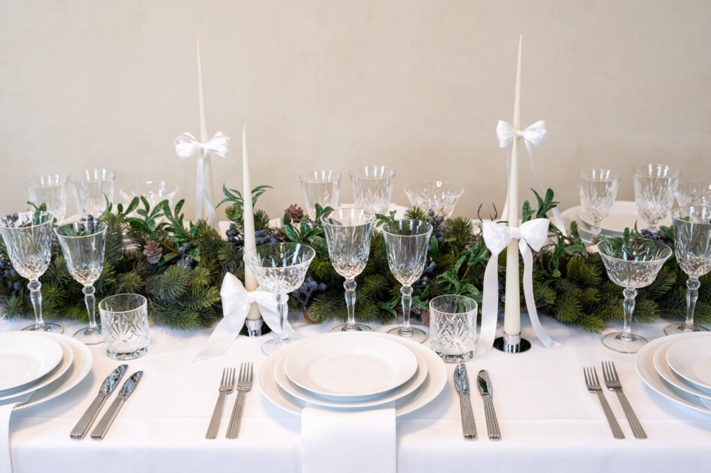 Elegant julebord med krystalklare glas og hvide lys